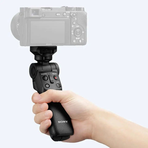 Person holding Wireless Bluetooth Shooting Grip And Tripod For Still Photos And Video Perfect For Vlogging Cable Free Remote Commander