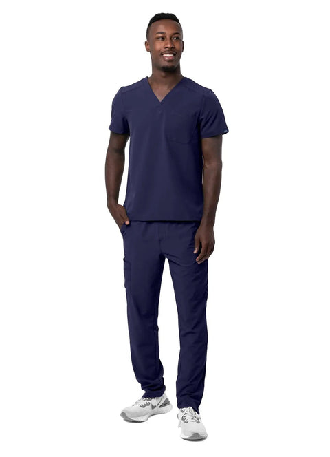 Mens Professional Medical Nursing Scrub Set Featuring Classic V Neck Top And Cargo Pants Crafted From Navy Blue No Drag Stretch Fabric Built Straight Up To Keep You Cool While Rocking Every Shift, model standing in navy scrub set.