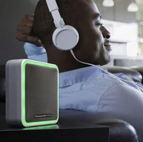 Person relaxing with headphones, next to Wireless Doorbell 9 Series With Push Button Blue Grey Portable Chime Adjustable Volume