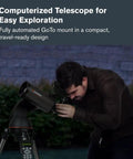 Person using NexStar 90SLT Mak Totally Portable Computerized Telescope With Star Locating in a garden at night