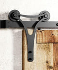 Close-up of Black Rustic Double Track U Shape Bypass Sliding Barn Door Hardware Kit with horns design rollers installed on wood door.