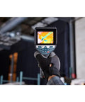 Person holding 12V Max Connected Thermal Camera With 500 Sharp Thermal Images Storage For On Site Inspections, Pro Grade Intuitive One Tap Interface For Fast Results, Built In Microphone And Speaker For Voice Notes And Easy File Transfer displaying thermal image on screen.