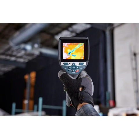 Person holding 12V Max Connected Thermal Camera With 500 Sharp Thermal Images Storage For On Site Inspections, Pro Grade Intuitive One Tap Interface For Fast Results, Built In Microphone And Speaker For Voice Notes And Easy File Transfer displaying thermal image on screen.