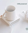 Electric Coffee Mug Warmer For Office Desk With Auto Shut Off Timer Keep Your Brew Piping Hot Straight Up Skip The Microwave Hassle Flat Bottom Cup Heater For Tea Coffee Milk And Quick Sips on a white surface with a USB connection.