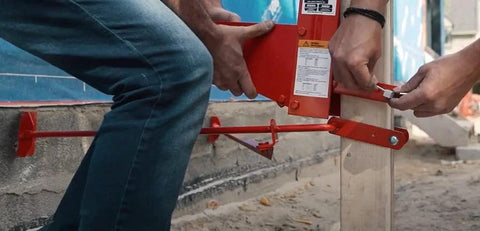 Metaltech Pump Jack Brace 2201, red metal automotive jack accessory, side view installed on a vertical post