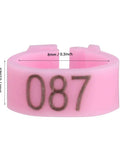 Closeup of pink 8mm bird leg ring numbered 087, part of 100 Pieces Pigeon Leg Bands 8mm Numbered Bird Leg Rings for Small Birds Poultry Foot Clips Clip On Weatherproof Plastic ID Tags for Finch Dove Lovebird Quail Health Tracking and Age Recording