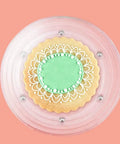 Level Up Your Baking Game With This Nifty 8 Inch Acrylic Cookie Decorating Turntable Kit Featuring Six Sturdy Brushes And Six Precision Scribe Tools For Flawless Icing And Sugar Craft Designs, featuring a decorated cookie on a clear turntable.