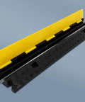 Close-up of Three Pack 2 Channel Cable Protector Ramps BeefedUp Built Tough For 11000 Lbs Per Axle, Yellow and Black design in focus.
