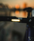 Dope Front Bike Light With USB Rechargeable Battery mounted on handlebar at dusk, showing illumination feature.