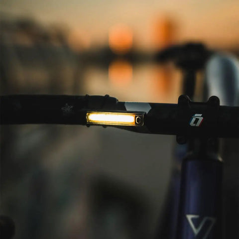 Dope Front Bike Light With USB Rechargeable Battery mounted on handlebar at dusk, showing illumination feature.