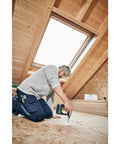 Rugged 18V Cordless Drill With Keyless Chuck And Belt Clip Compact Ergonomic Handle used for fastening in a wooden attic workspace.