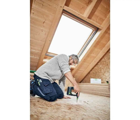 Rugged 18V Cordless Drill With Keyless Chuck And Belt Clip Compact Ergonomic Handle used for fastening in a wooden attic workspace.