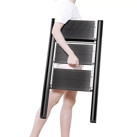 Person carrying the Pro Grade Electric Attic Staircase With Remote Control And Foldable Telescopic Ladder for easy transport.