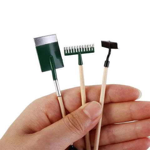 Hand holding 1:12 Dollhouse Mini Garden Tool Set With Shovel Hoe And Pitchfork, Tiny Hand Planting Tools, Wood Handles, Realistic Decor