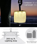 Two In One Solar Camping Lantern And Phone Charger Inflatable LED Light shown glowing at dusk, 6-inch size, lighting area example.
