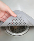 Person placing a Two Pack Shower Drain Hair Catcher With Strong Suction Cups over drain to prevent clogs in a kitchen sink.