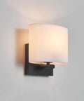 AuroraSpher Indoor Hardwired Modern Milky White Acrylic Black Wall Sconce mounted on a light wall, showcasing a sleek design.