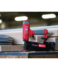 Pro Grade Pneumatic Pin Nailer For Cabinet Trim And Fine Woodworking Ships Ready Using Twenty One Gauge Straight Collated Pins From Half Inch To Two Inches, positioned on wood with hose in background.
