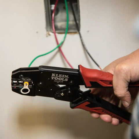 Person using Pro-Grade Wire Stripper And Ratcheting Crimper Kit For Insulated Terminals on electrical wires near panel