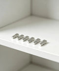 80 Pack 5mm Cabinet Shelf Pegs With Spoon Shape Design, nickel plated iron pins displayed on a white shelf for stability use