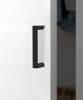 Close-up of Set Of 10 Matte Black 3 Inch Cabinet Handles Center To Center 76mm Drawer Pulls Zinc Alloy Hardware on white door.