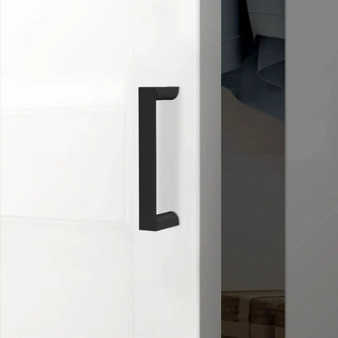 Close-up of Set Of 10 Matte Black 3 Inch Cabinet Handles Center To Center 76mm Drawer Pulls Zinc Alloy Hardware on white door.