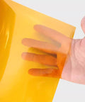 Hand holding translucent golden Non Adhesive Polyimide Film Sheet 200mm x 300mm High Temperature Resistant PI Film For Electrical Insulation 0.025-0.25mm Thick