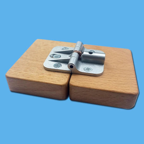 Front view of a silver zinc-alloy adjustable torque folding table hinge mounted on two wooden blocks; screws visible