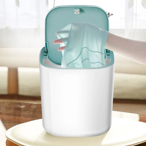 Knock Out Your Laundry Hustle With Slick Portable Mini Washing Machine Featuring blue drum as a hand places thin garment inside.