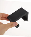 Hand holding a black rattan chair clamp from 12 Pieces Rattan Chair Clamps And Wicker Furniture Clips For Outdoor Couches And Sectionals Quick Install Easy Snap On No Tools Needed Secure Cushions In Place Patio Garden