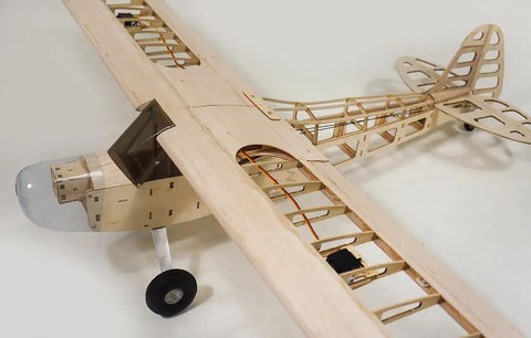 Partially assembled RC Balsa Airplane Kit Piper Cub J3 with 46 inch wingspan, showcasing wooden frame and realistic cowl and landing gear.