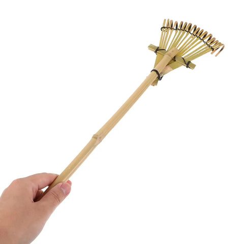 Hand holding Solid Bamboo Garden Rake For Sandboxes And Landscaping, Lightweight Eco Friendly Yard Tool, 19.7 Inch, Japanese Inspired Design