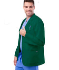 Pro Approved Unisex Lab Coat For Healthcare Crew Featuring Stacks Of Storage In Dual Patch Pockets And A Handy Chest Divider Classic Hunter Green Cut With A 31 Inch Back Hem Built Tough For Long Haul Clinic Days, modeled by man in scrubs with a thumbs up.
