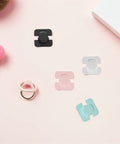 4 Pack Kid Proof Fridge And Cabinet Latch Set With Invisible Design Made From ABS Material For Safe Home And Kitchen Use Easy No Tool Installation Keeps Curious Toddlers Safe In Cabinets shown in pink, black, clear, and blue on a pastel background.