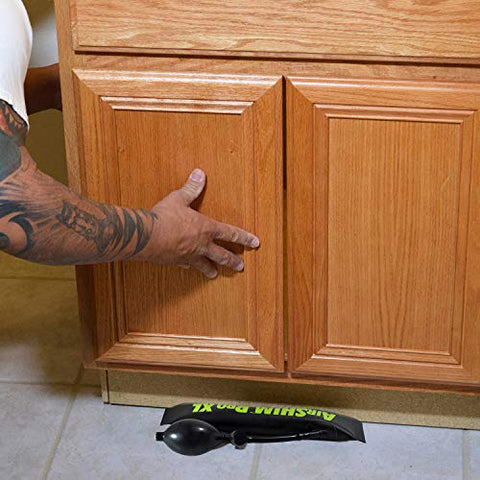 Calculated Industries 1194 Air Shim XL inflatable pry bar under kitchen cabinet; black hand-operated pump wedge visible.