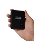 Hand holding Battery Operated Phone Charger With LED Light And USB Output Emergency Power Bank Powered By 4 AA Batteries Portable 2 Pack Black