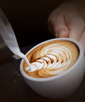 Top Shelf Semiautomatic Espresso Maker With A Mean 20 Bar Pump And Sleek Milk Frother pouring milk into latte art in white cup.
