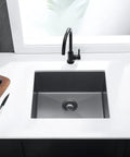 Top view of a drop-in kitchen sink single bowl workstation stainless steel 16 gauge black with strainer in a modern kitchen setup.