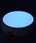 Depisuta 22cm Electric Rotating Turntable Display Stand With Led Colorful Light Remote Control displaying blue LED light.