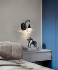 Crystal Bubble Wall Sconce With Dimmable LED 5W, 3300K Warm White, Matte Black Finish, on a bedroom wall above a nightstand