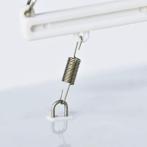 Close-up of a metal spring component on the Voyager 280 Wind Powered RC Sailboat In Red With Two Channel Control Water Rudder and Sail Angle