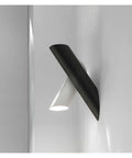 Rock Solid Black Iron Wall Sconce With Pivot Led Fixture And Chill Warm Glow Modern Minimalist Bedside Lighting on gray wall.