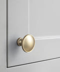 Close-up of 12 Pack Champagne Bronze Cabinet Knobs 1.25 Inch Round Heavy Duty Zinc Alloy Hardware on gray cabinet