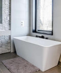 Modern bathroom with Matte Black Waterfall Tub Faucet With Widespread Spout, Deck Mount Roman Tub Filler near a white tub.