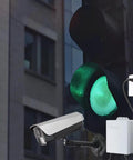 Compact 12V 2A Mini UPS Battery Backup For Routers And CCTV Cameras, white unit powering camera near green traffic light