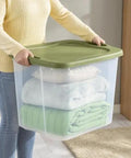 Rock Solid 95 Quart Clear Plastic Storage Bin With Easy Grip Handles for carrying folded blankets in a home setting.