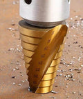 Close-up of a gold titanium-coated step drill bit in a drill chuck; size markings visible