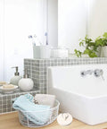 Bathroom with white tub, grey tiles, and Four Piece Bath Tub And Sink Drain Stoppers Set With Hanging Ring Flexible Rubber Plugs nearby.