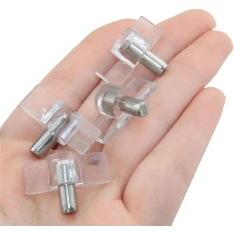 Hand holding clear plastic cabinet shelf pins for removable glass panels and wood shelves heavy duty and easy to install