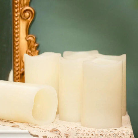 Flickering Flameless LED Candles Real Wax Pillar Set Of 6 on a lace table, battery operated pillars 5 inches tall by 3 inches wide